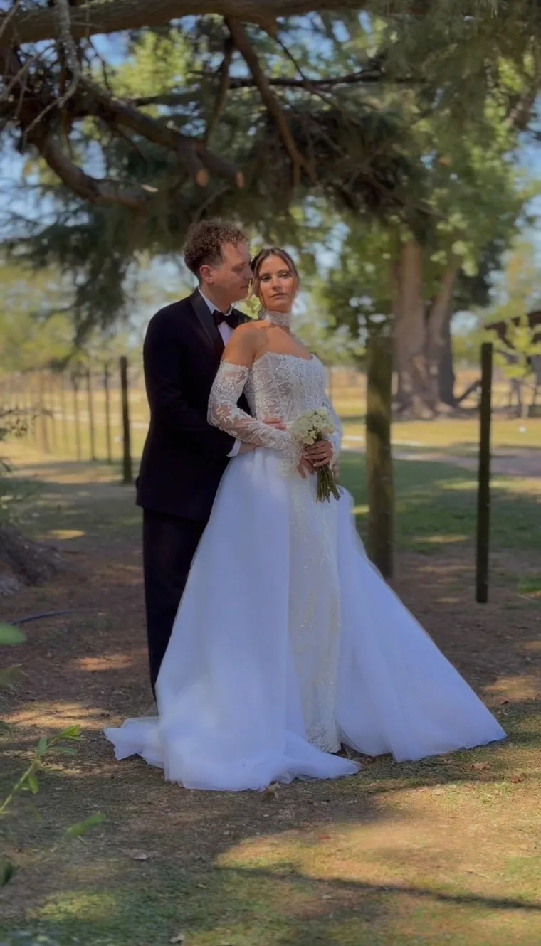 Andre y Dami abrazados bajo un árbol el día de su casamiento